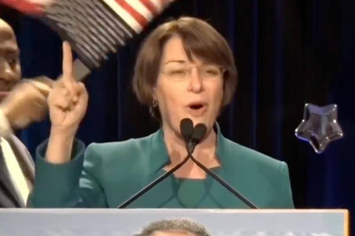 Amy Klobuchar brags about helping Somalis send your tax dollars to Somalia…in front of upside down American flag