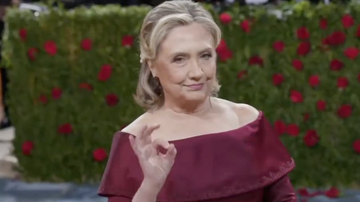 Hillary Clinton Stuns Paparazzi in Blood Red Dress As Black Servant in Mask Tends to Her