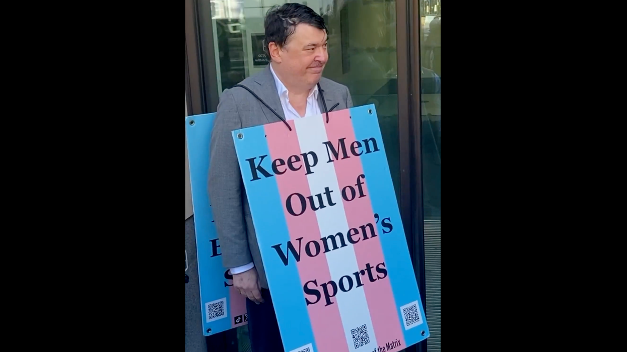 Comedian arrested for "anti-trans" social media posts doubles down wearing "anti-trans" billboard outside of court